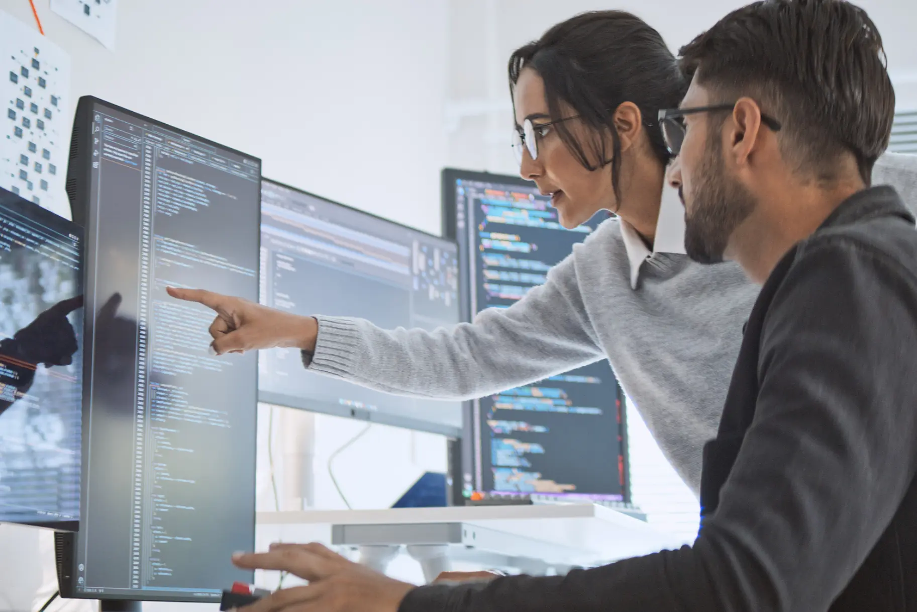 Equipo creativo revisando wireframes de interfaz y flujo de producto digital sobre una mesa de trabajo.